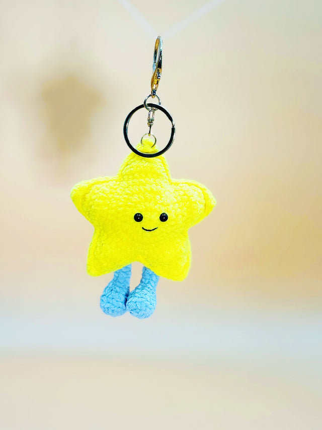Yellow star-shaped keychain with a smiley face on a blurred background