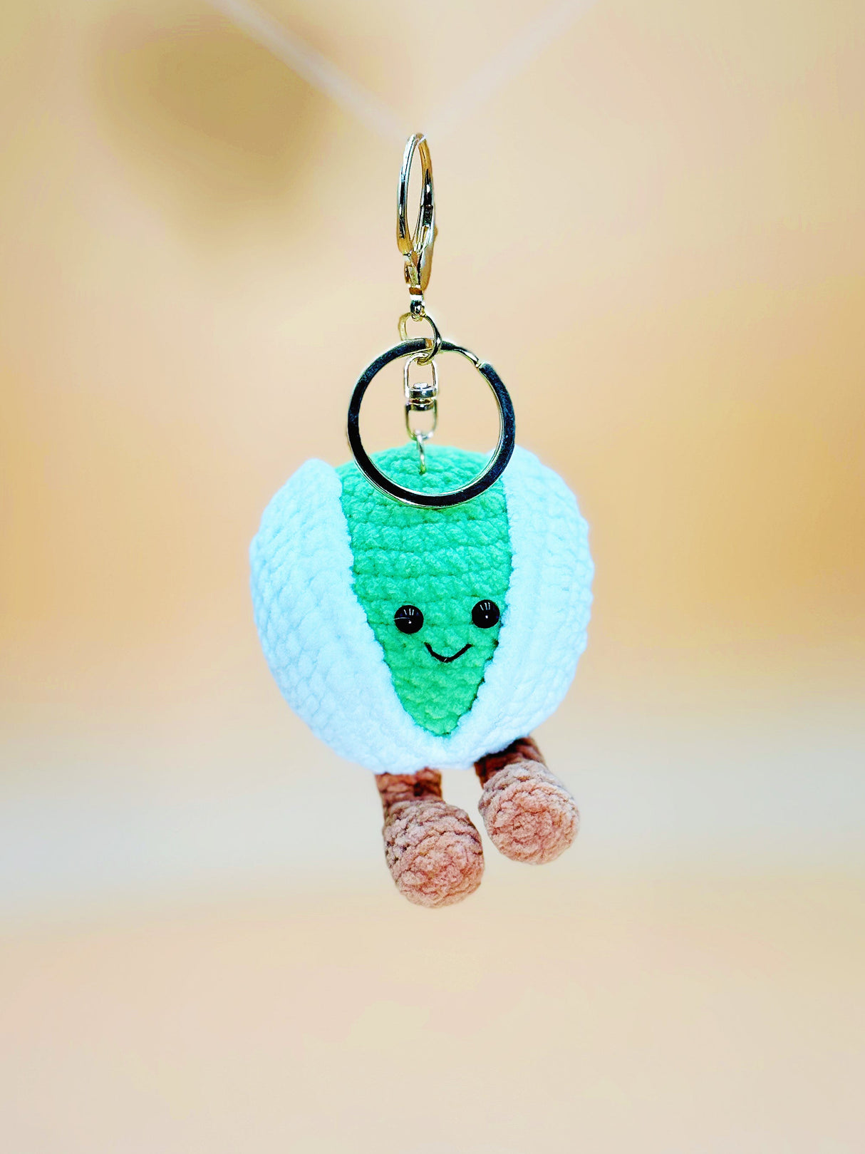 Crocheted keychain with a smiling face on a blurred background