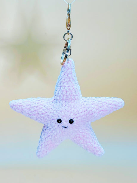 Star-shaped keychain with a smiling face on a blurred background