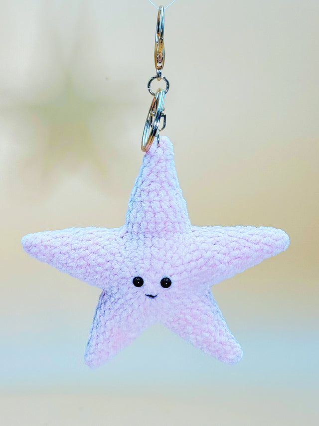 Star-shaped keychain with a smiling face on a blurred background