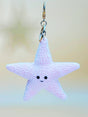 Star-shaped keychain with a smiling face on a blurred background